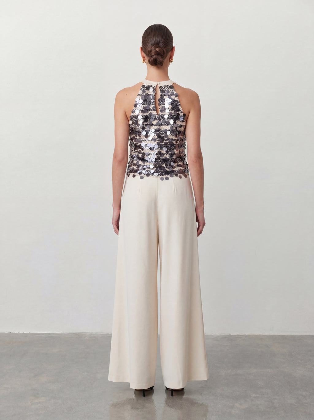 Elegancki komplet wieczorowy z cekinowym topem halter i szerokimi spodniami – srebrno-ecru