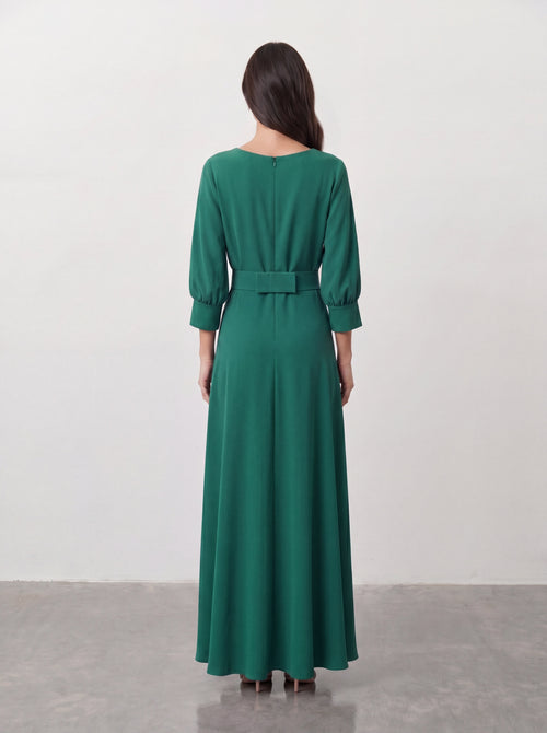Elegancka sukienka maxi w butelkowej zieleni z kopertowym dekoltem V, rękawami balonowymi i kwiatem z tkaniny przy talii